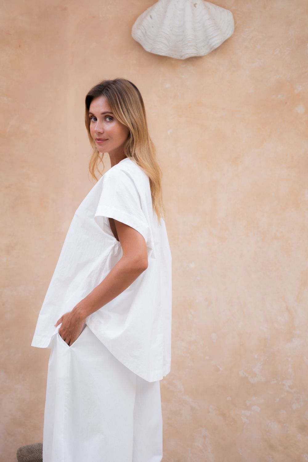Oversized white cotton poplin button-up tee with curved hem.